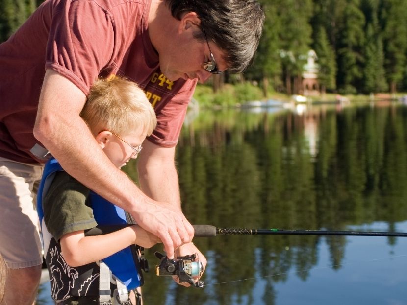 father and child fishing together at l'étang du merle campsite in burgundy